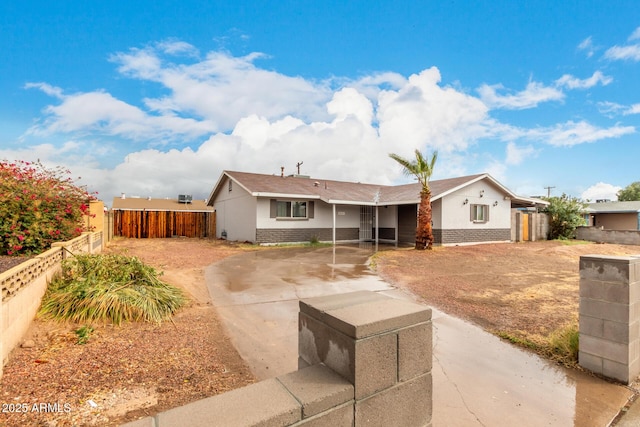 ranch-style home with concrete driveway, a fenced backyard, and brick siding