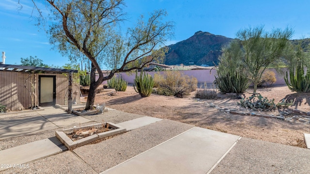 exterior space with a mountain view, a patio, and an outbuilding