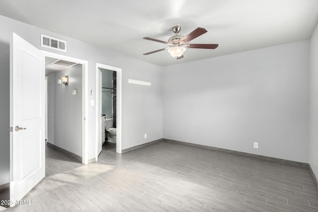 unfurnished bedroom with a walk in closet, ceiling fan, light wood-type flooring, connected bathroom, and a closet