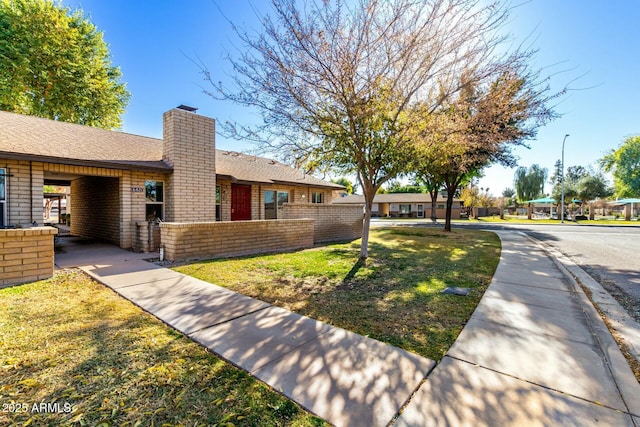 exterior space with a front lawn and a carport