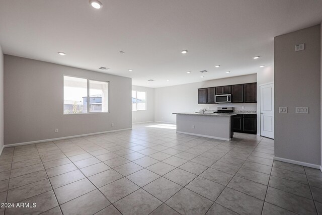 unfurnished living room with light tile patterned floors and sink