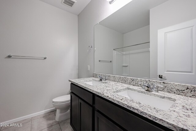 bathroom with tile patterned flooring, a shower, vanity, and toilet