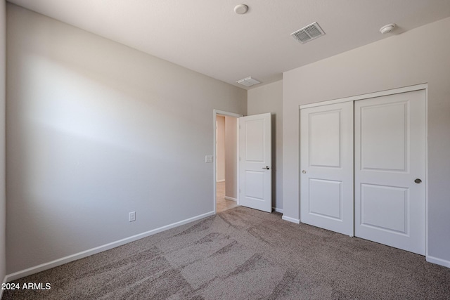 unfurnished bedroom with carpet floors and a closet