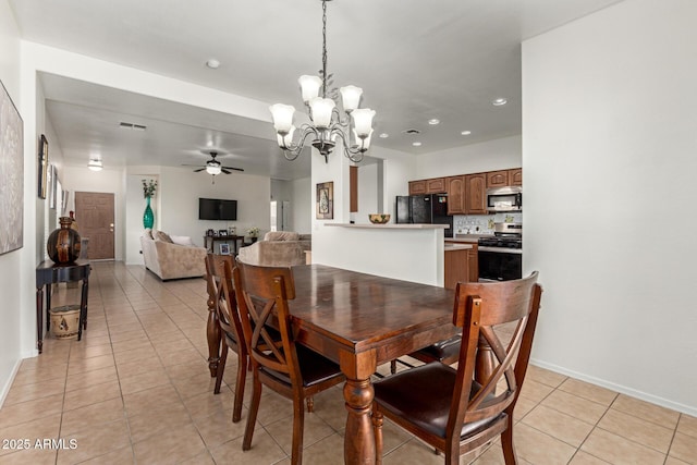 tiled dining room with ceiling fan with notable chandelier