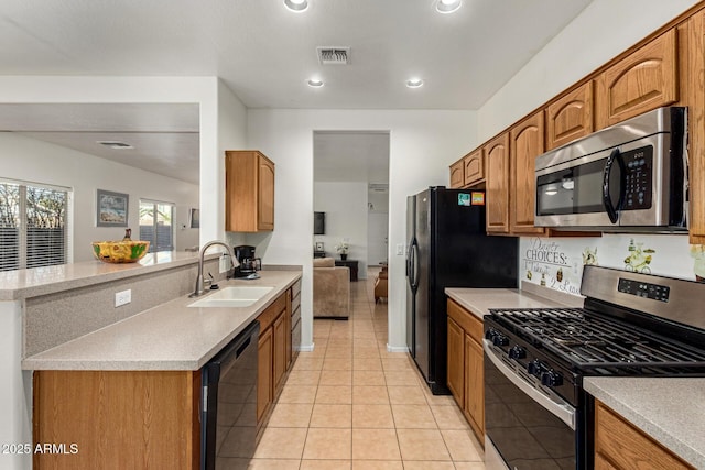 kitchen featuring sink, light tile patterned floors, and black appliances