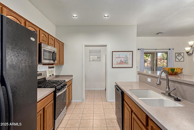 kitchen featuring black appliances, sink, and light tile patterned flooring