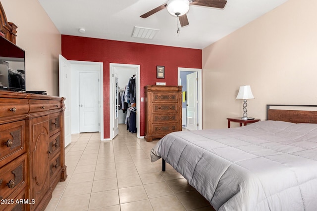 bedroom featuring ceiling fan, ensuite bath, light tile patterned flooring, a spacious closet, and a closet