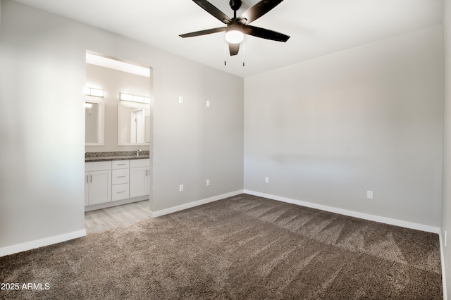 unfurnished bedroom featuring connected bathroom, ceiling fan, sink, and light carpet