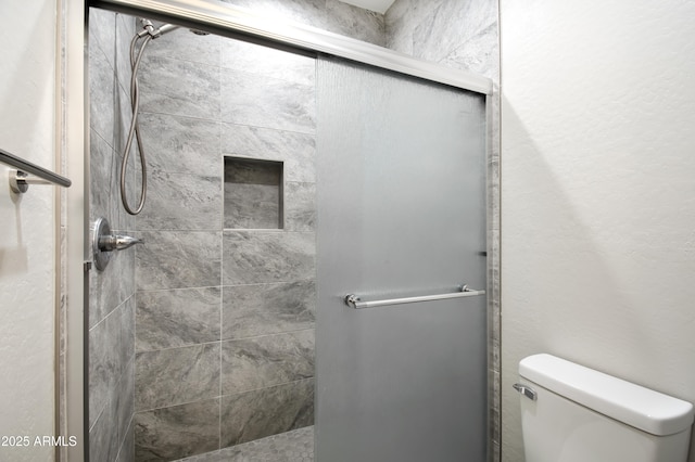 bathroom featuring an enclosed shower and toilet