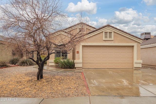 view of front of home featuring a tile roof, stucco siding, concrete driveway, central AC unit, and a garage