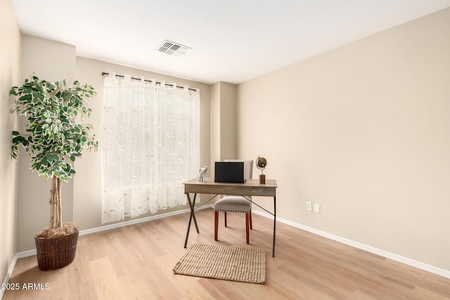 home office with visible vents, baseboards, and wood finished floors