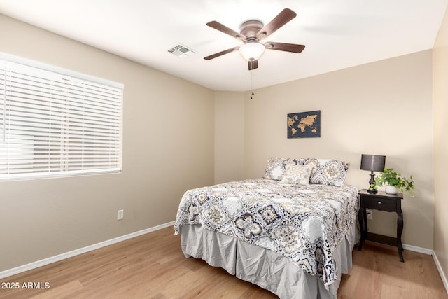 bedroom with baseboards, visible vents, ceiling fan, and wood finished floors