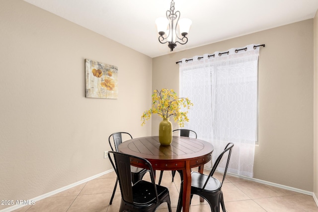 dining space with an inviting chandelier, light tile patterned floors, and baseboards