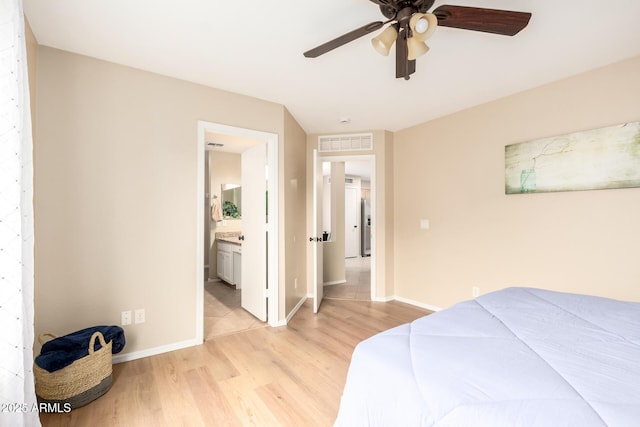 bedroom featuring visible vents, baseboards, a ceiling fan, light wood-style flooring, and ensuite bathroom