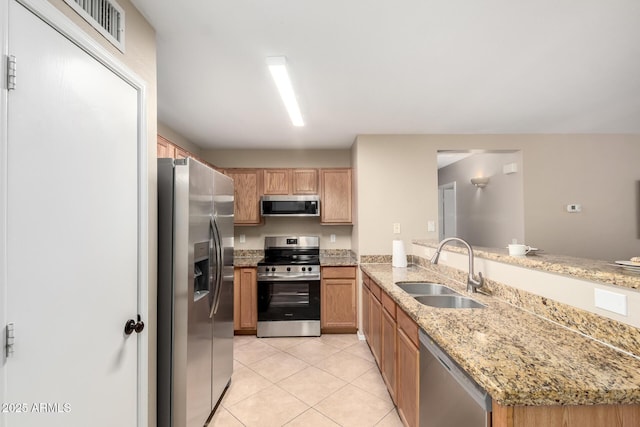 kitchen with light tile patterned floors, visible vents, appliances with stainless steel finishes, a peninsula, and a sink