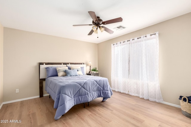 bedroom featuring ceiling fan, wood finished floors, visible vents, and baseboards