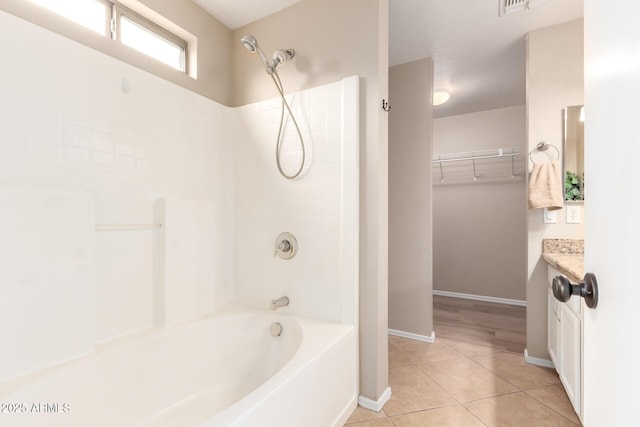 full bath featuring shower / bath combination, baseboards, tile patterned flooring, a walk in closet, and vanity