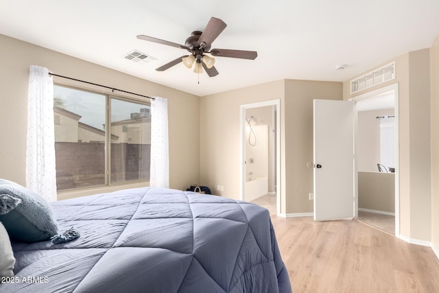 bedroom with baseboards, visible vents, a ceiling fan, ensuite bath, and light wood-style floors