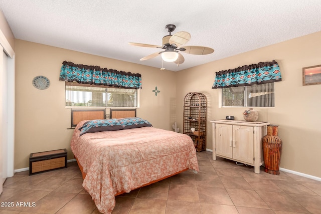 tiled bedroom featuring ceiling fan and a textured ceiling