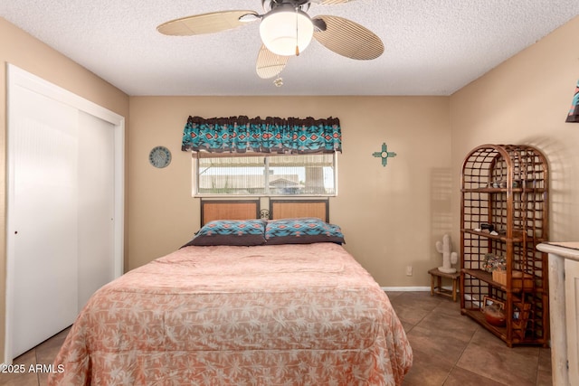 tiled bedroom featuring ceiling fan and a textured ceiling