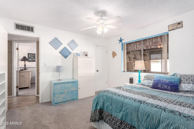 bedroom featuring ceiling fan, light carpet, and a textured ceiling