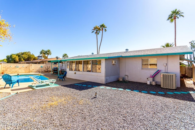 rear view of property featuring central AC, a fenced in pool, and a patio area