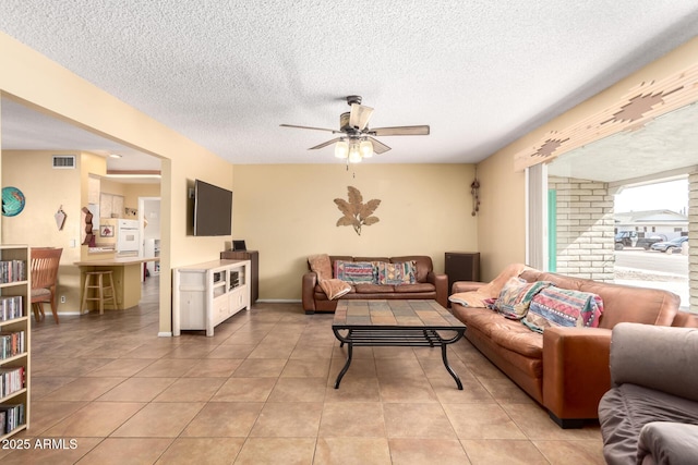 tiled living room featuring a textured ceiling and ceiling fan