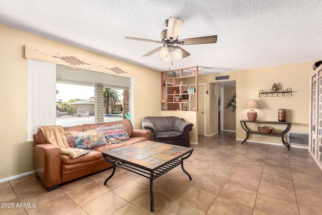 tiled living room featuring ceiling fan and a textured ceiling