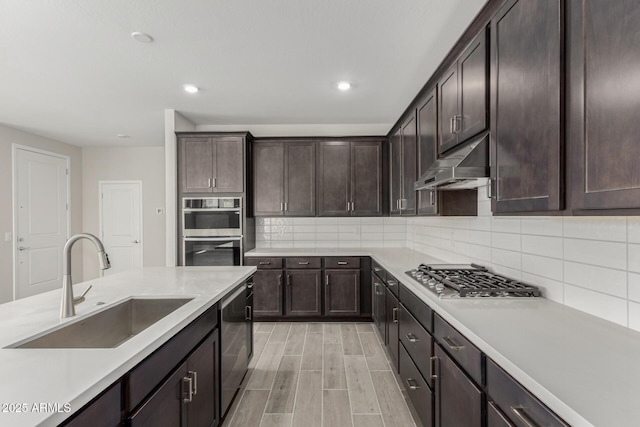 9416 E Sequence Ave, Mesa, AZ 85212 - kitchen with under cabinet range hood, appliances with stainless steel finishes, dark brown cabinetry, backsplash, and recessed lighting