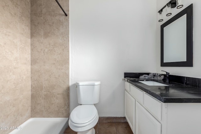 bathroom with vanity, toilet, tiled shower, and tile patterned flooring