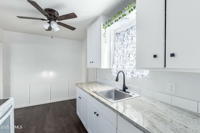 kitchen featuring light stone countertops, white cabinets, sink, dark hardwood / wood-style flooring, and ceiling fan