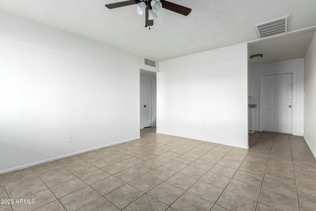 tiled empty room featuring ceiling fan and a textured ceiling