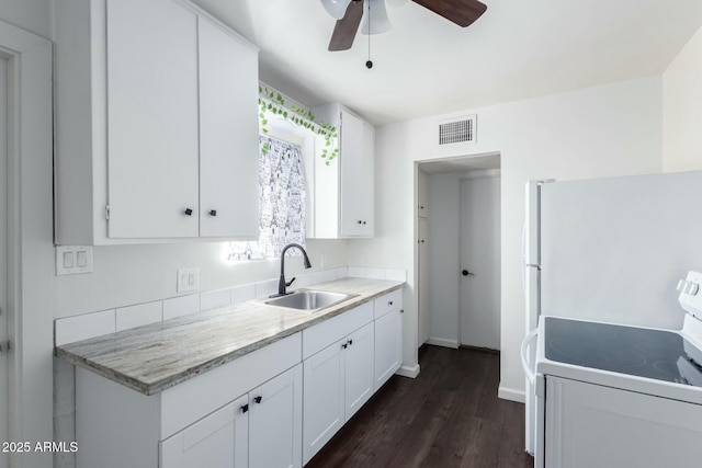 kitchen with ceiling fan, dark hardwood / wood-style flooring, sink, white cabinets, and white appliances