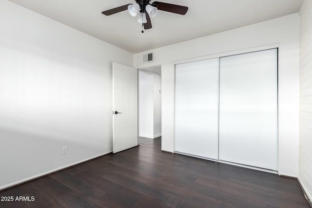 unfurnished bedroom featuring ceiling fan, a closet, and dark hardwood / wood-style flooring