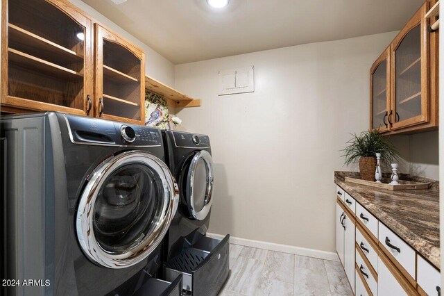 laundry room with independent washer and dryer, light tile patterned flooring, and cabinets