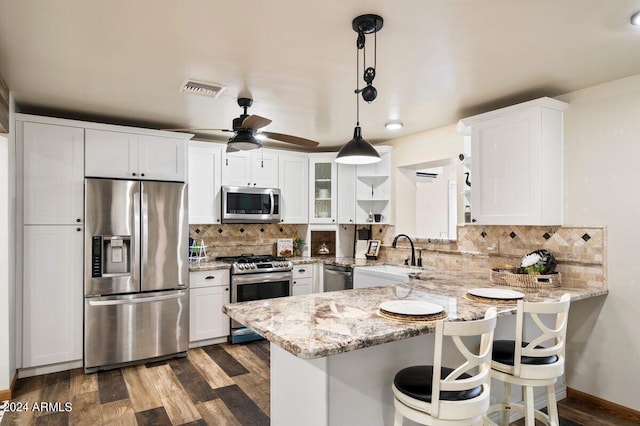 kitchen featuring appliances with stainless steel finishes, white cabinets, and kitchen peninsula