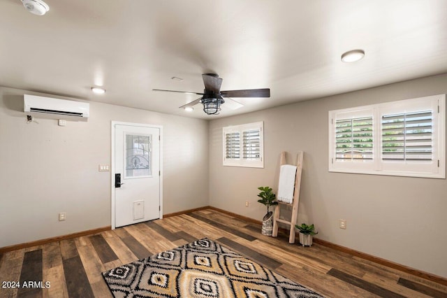 entryway with dark hardwood / wood-style flooring, ceiling fan, and a wall unit AC