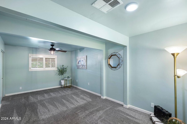 empty room featuring dark carpet and ceiling fan