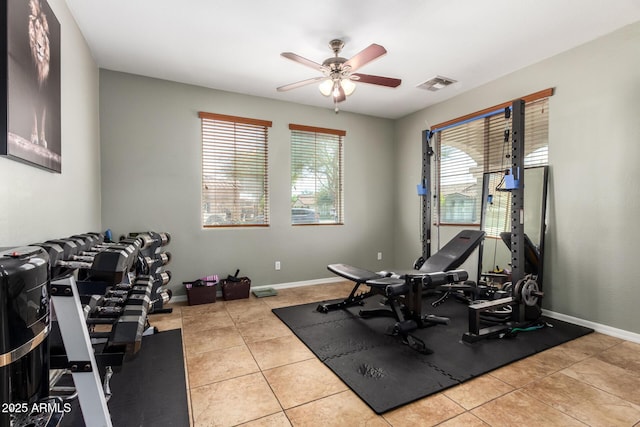 workout room featuring tile patterned floors, visible vents, baseboards, and ceiling fan