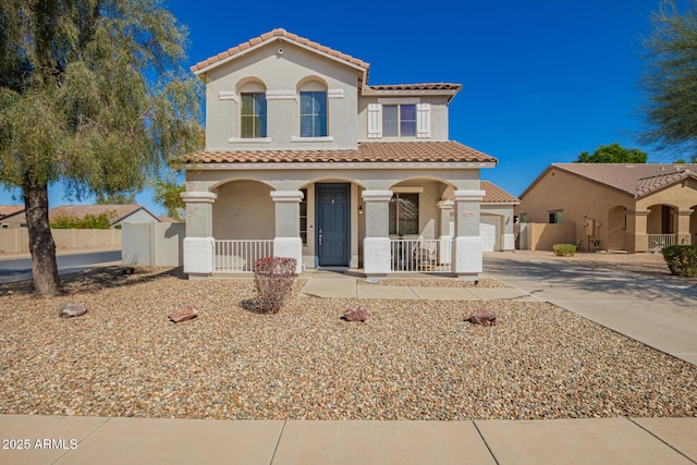 mediterranean / spanish house with fence, covered porch, stucco siding, concrete driveway, and a tile roof