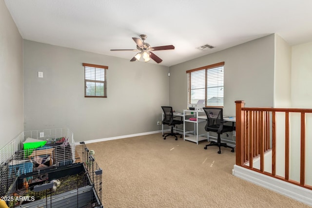 carpeted office with plenty of natural light, baseboards, visible vents, and a ceiling fan