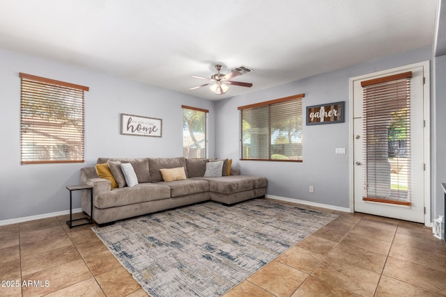 living area featuring tile patterned flooring, visible vents, ceiling fan, and baseboards