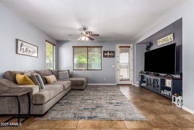 living room with tile patterned floors, ceiling fan, and baseboards