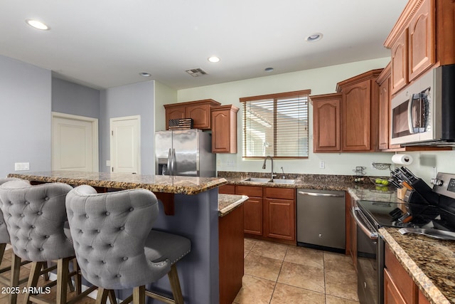 kitchen featuring a breakfast bar, recessed lighting, a sink, stainless steel appliances, and a center island