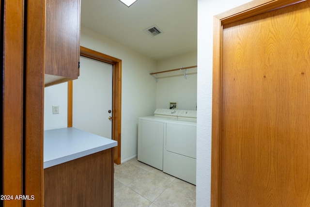 washroom featuring light tile patterned floors, cabinets, and washing machine and clothes dryer