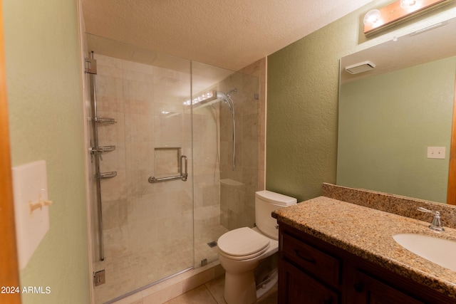 bathroom featuring toilet, a textured ceiling, vanity, and a shower with door