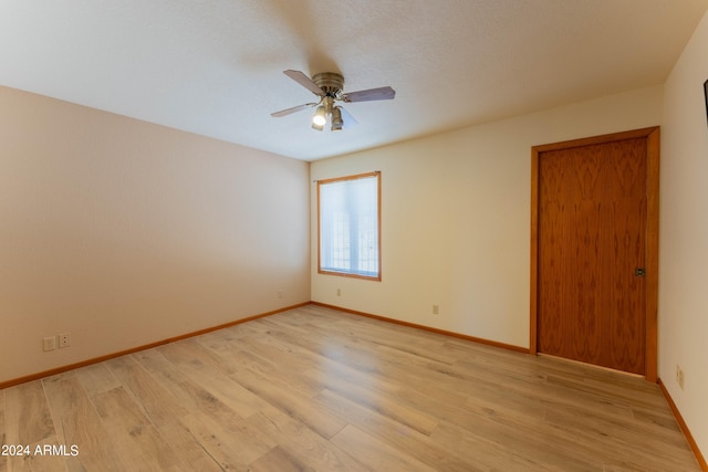 spare room featuring light wood-type flooring and ceiling fan