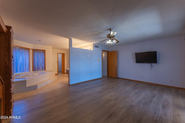 unfurnished living room featuring ceiling fan and wood-type flooring