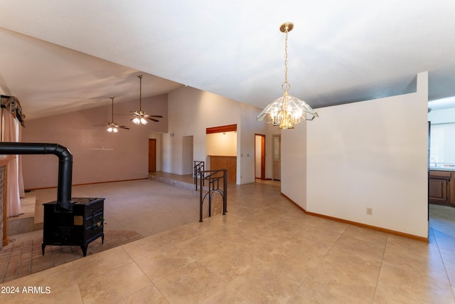 interior space with high vaulted ceiling, a wood stove, and ceiling fan with notable chandelier