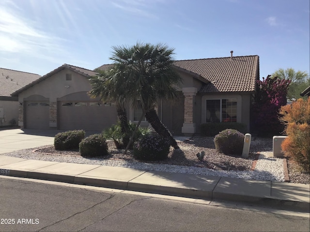 ranch-style house with a tile roof, stone siding, a garage, and stucco siding